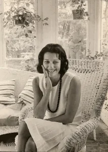 Imagen en blanco y negro de Anne Sexton sonriente y con vestido blanco