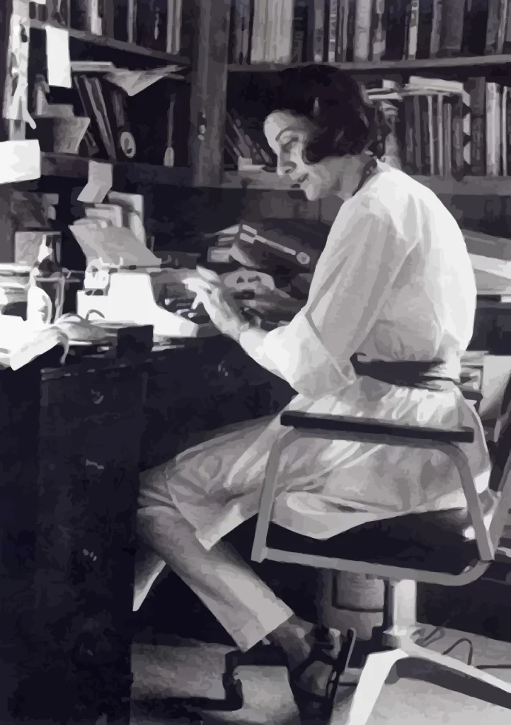 Anne Sexton sentada en su escritorio mecanografiando textos